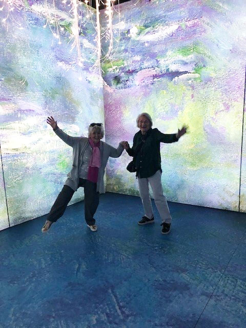Samford Grove residents with digital screen of Monet's waterlily artwork behind them.