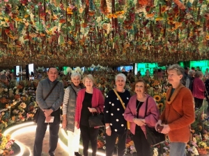 Samford Grove residents smiling in interactive flower room at Monet in Paris exhibit.