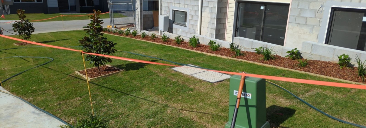 Green garden complete at Samford Grove with orange tape around the grass.